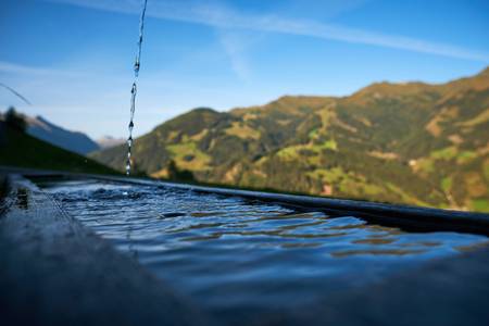 Holzbrunnen auf der Alm mit frischem sprudelndem Quellwasser 2020